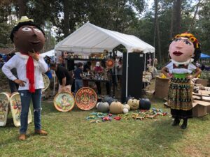 Courtesy Dina Willis Giant monas stand near booths at the La Fiesta del Pueblo festival in Tipton, Ga. Monas are puppets handmade from cardboard materials. The puppets, worn by people, originated in Spain and were brought to Mexico around 1600.