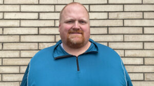 Chris Brawner, new director of operations for the Kentucky Exposition Center, poses in front of a brick wall. 