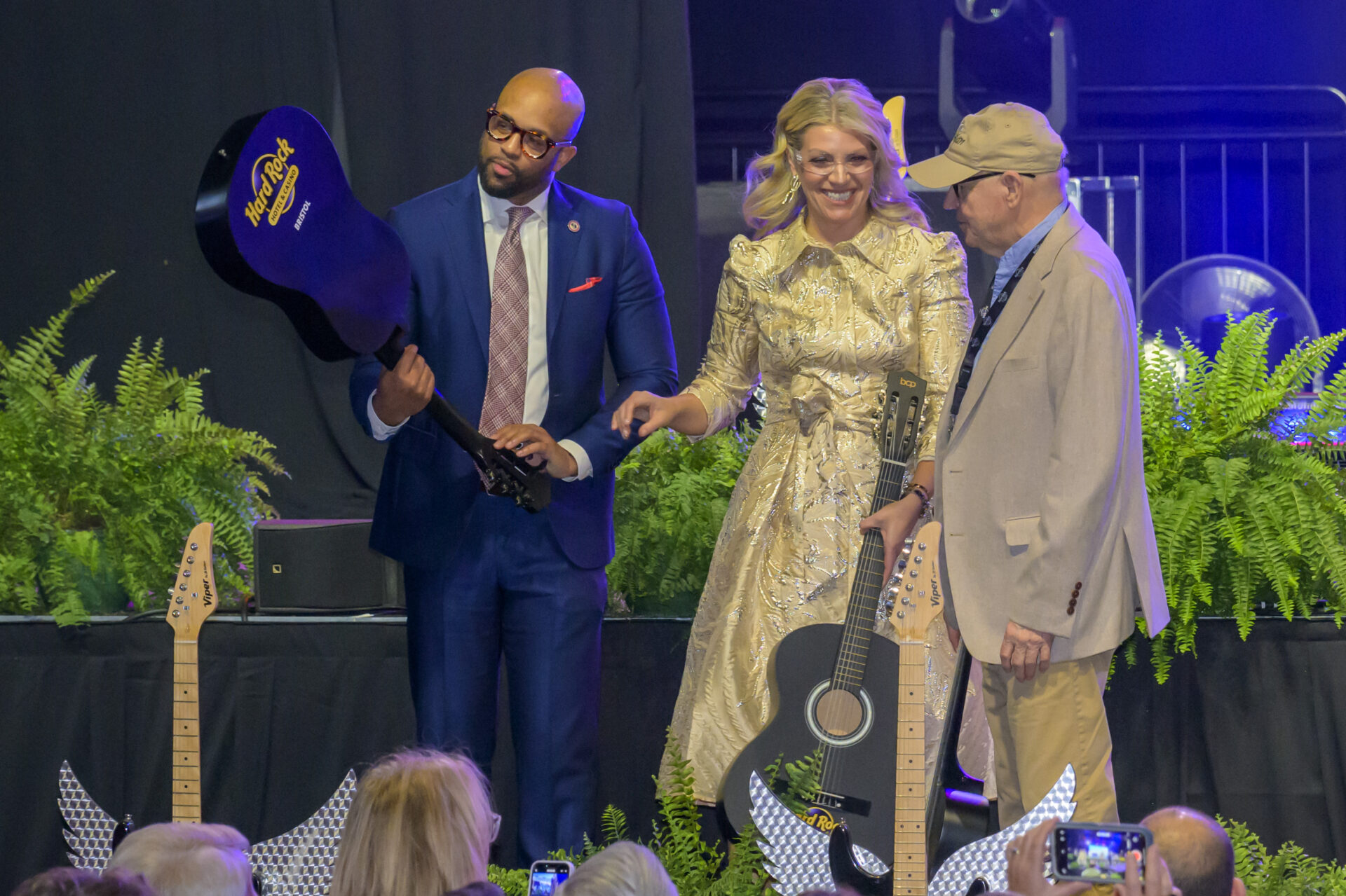 Three people with guitars on stage.