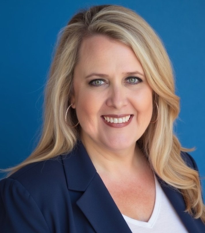 A headshot of Gayle Guyse in a blue blazer and blonde hair.