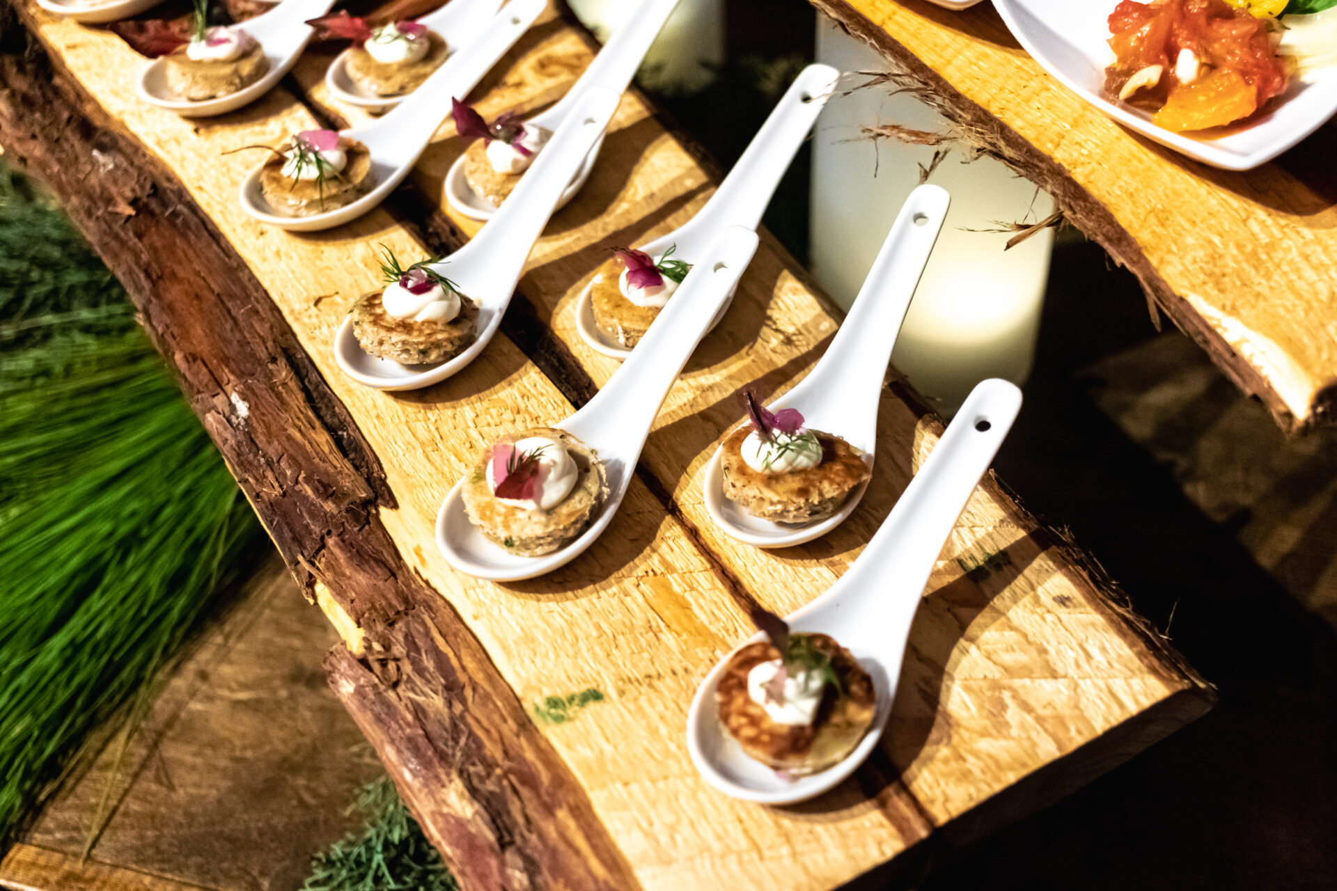 Single-serve appetizers on white spoons.