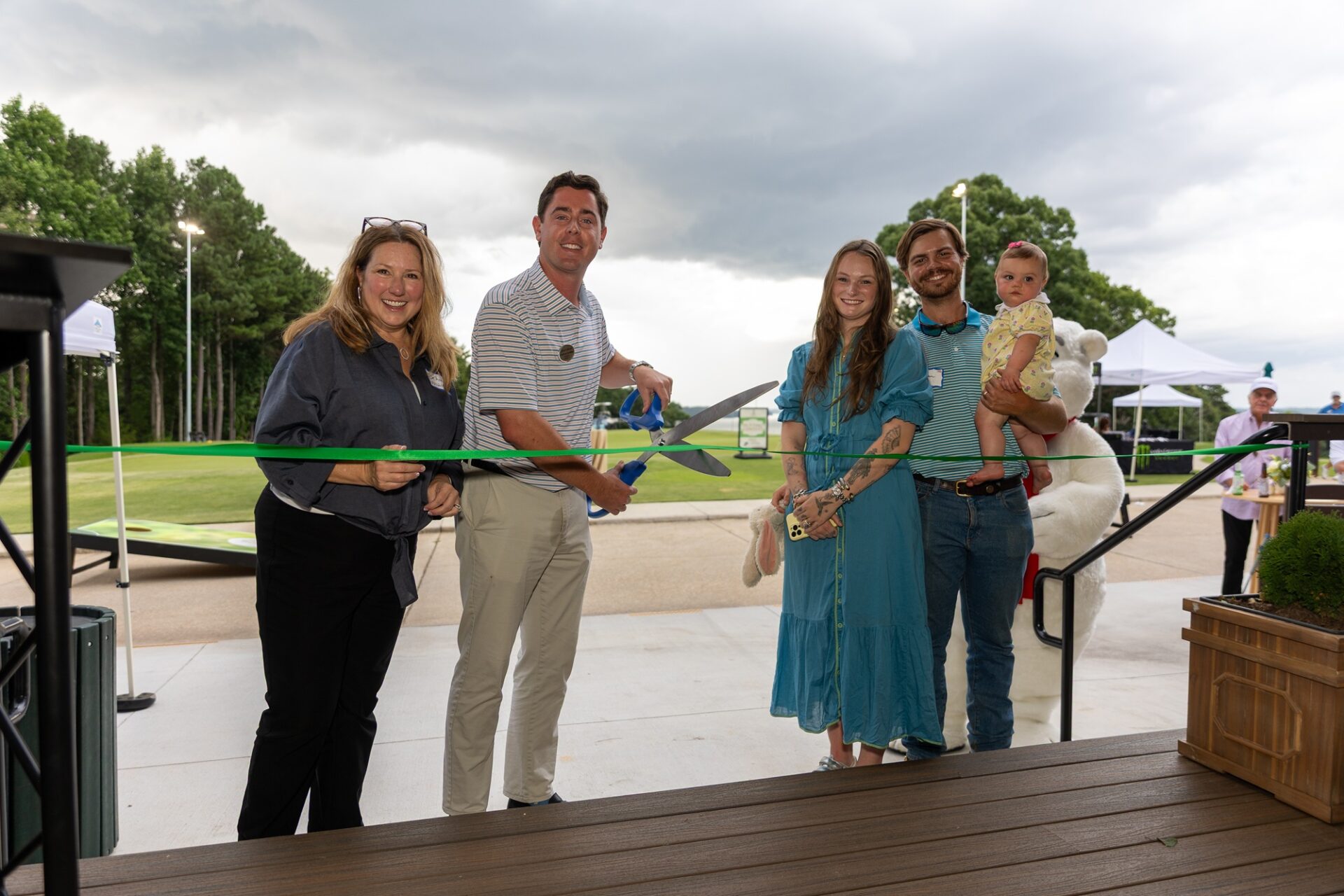 A group of people posing for a ribbon cutting ceremony.